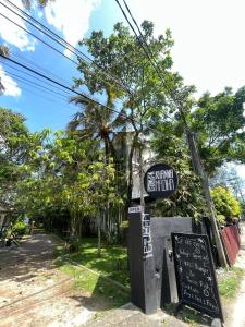 a sign for a restaurant on the side of a street at Backpackers in Matara