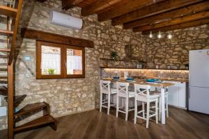 una cucina con tavolo e sgabelli in una stanza di Villa Stone Walls with Jacuzzi a Castellammare del Golfo