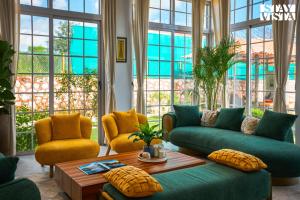 a living room with a couch and two chairs and a table at StayVista's Rustique Radiance - Hillside Retreat with Outdoor Pool & South Indian Architecture in Khopoli