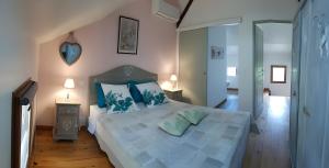 ein Schlafzimmer mit einem großen Bett mit blauen Kissen in der Unterkunft Gite Jardin De Pomarede in Prigonrieux