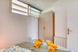 - une chambre avec un lit et des serviettes jaunes dans l'établissement Appartement à 70m de la plage, à La Grande Motte