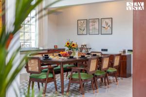 a dining room with a table and chairs at StayVista's Rustique Radiance - Hillside Retreat with Outdoor Pool & South Indian Architecture in Khopoli +26 photos