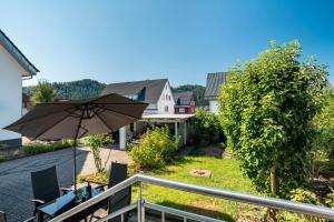 a patio with an umbrella and chairs on a balcony at Zum alten Wald in Zell am Harmersbach