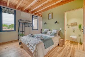 a bedroom with a bed and a large window at Les Echaunes in Caraman