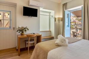a bedroom with a bed and a desk and a tv at Casa das Andorinhas in Câmara de Lobos