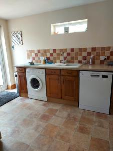 eine Küche mit Spüle und Waschmaschine in der Unterkunft Coastline cottage in Pakefield