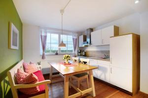 a kitchen and dining room with a table and chairs at Haus am See - zur roten Tür in Templin