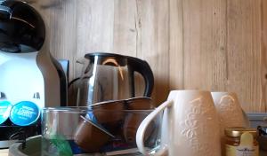 a coffee pot and a cup on a counter at Appartamento La Mirage in Livigno +4 photos