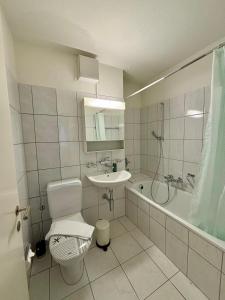 un bagno bianco con un water e un lavandino di Basic & Simple on Langgrütstrasse a Zurigo Altre 17 foto