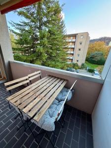 una panca di legno seduta su un balcone con un albero di Basic & Simple on Langgrütstrasse a Zurigo