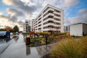 ein weißes Wohnhaus in einer regnerischen Straße in der Unterkunft Szeligowska, Sun & Snow in Warschau