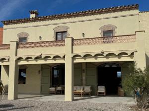 an exterior view of a building with a balcony at Mas Les Arrabassades in Castelló d'Empúries