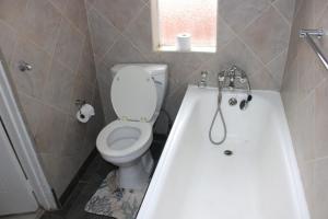 a bathroom with a toilet and a bath tub at Chic Guest House Alberton in Alberton +52 photos