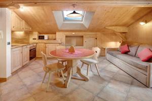 a kitchen and dining room with a table and a couch at Appartamento Cirmolo Chalet Cambra in Livigno