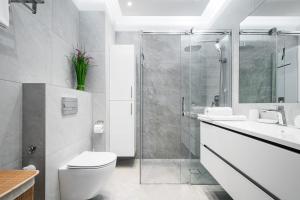 ein Badezimmer mit Dusche, Toilette und Waschbecken in der Unterkunft Szeligowska, Sun & Snow in Warschau