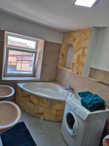 a bathroom with a tub and a washing machine at Appartement Aurach A6 in Aurach +11 photos
