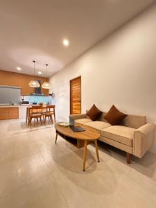een woonkamer met een bank en een tafel bij Baan Suan Poolsap - Haad Rin Beach in Haad Rin