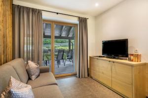 Una sala de estar con un sofá y un televisor de pantalla plana. en Wiesgut Apartment Stark, en Tesimo