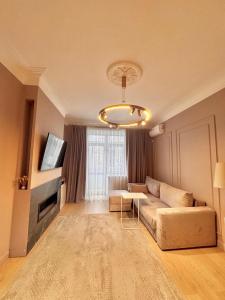 a living room with a couch and a tv at Central Park Apart in Karagandy