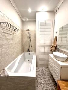 a bathroom with a white tub and a sink at Central Park Apart in Karagandy +5 photos