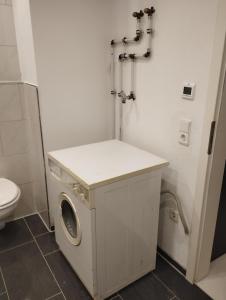 a washing machine in a bathroom with a toilet at Appartement Las Maria in Haigerloch +5 photos
