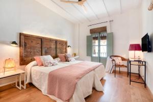 a bedroom with a large bed with a wooden headboard at Ca la Pasita 28 in Beniali +17 photos
