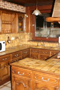 a kitchen with wooden cabinets and a sink at La Maison de Yana in Saint-Marcel-dʼArdèche