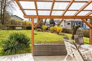 a patio with two chairs and a pergola at Mitterfelder Donaublick in Vilshofen an der Donau