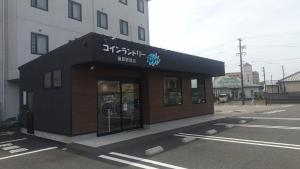 a building in a parking lot next to a building at Tabist Station Hotel Isobe Ise-Shima in Shima