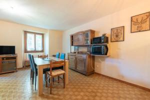 a kitchen and dining room with a table and a microwave at Gite Dans Grange Foraine - Ruisseau in Artalens-Souin