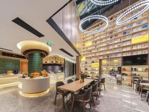 a restaurant with tables and chairs in a building at Atour S Hotel Wuxi Nanchang Street in Wuxi