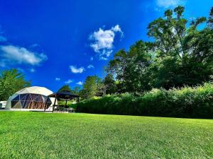 a gazebo in a field with a grass field at Glamping x Kominka MASAZUMI Tei -and- GLAMPING&BBQ VILLAGE Takibi Terrace - Vacation STAY 97095v in Kawabe