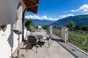 テージモにあるFlorianshofのバルコニーにテーブルと椅子が置かれたパティオ