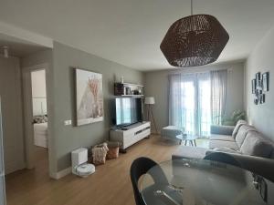 Una sala de estar con un sofá y un televisor. en El Rincón del Charco, en Arrecife