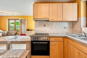 Zell im WiesentalにあるHaus Landblickの木製のキャビネットとコンロ付きオーブンを備えたキッチン