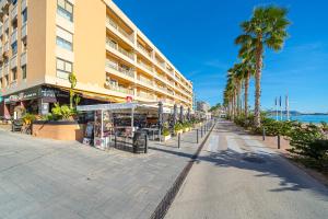 eine leere Straße vor einem Hotel mit Palmen in der Unterkunft Apto Villajoyosa 1ª línea in Villajoyosa