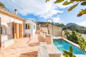 a villa with a swimming pool and a house at Can Titina in Puigpunyent