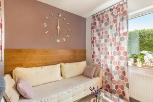 a clock on a wall above a couch in a room at Ferienwohnung Sonnenblick und Relax in Nieder-Röhre