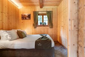 a bedroom with a bed in a wooden cabin at Baita Valon - Alpine Hideaway in Comano Terme