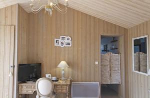 a room with a toilet and a desk with a television at Le Clos De La Combe in Saint-Jean-dʼOrbetiers