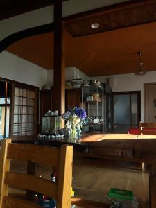 農家民宿ととのや في كانازاوا: غرفة مع طاولة مع إناء من الزهور عليها