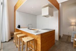a kitchen with a sink and a counter with stools at Casa Vermelha ii in Faro +14 photos