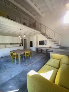 a living room with a yellow couch and a table at Villetta La Cellula in Marina di Campo