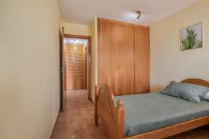a bedroom with a bed and a wooden cabinet at Palm Serenity in Playa Paraiso +23 photos
