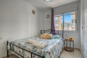 a bedroom with a bed and a window at Apartamento en playa de Daimús in Puerto de Gandía +12 photos