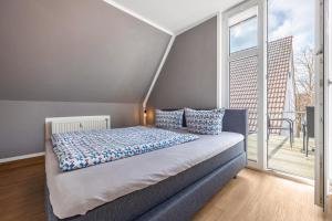 a bedroom with a bed and a large window at Meisennest 9 in Buchholz