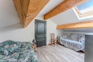 a bedroom with a bed and a chair in a attic at Duplex à deux pas de l'océan in Biscarrosse