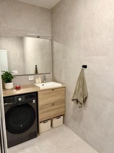 a bathroom with a washing machine and a sink at New modern apartment in Sandefjord