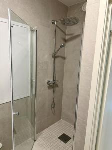 a shower with a glass door in a bathroom at New modern apartment in Sandefjord +6 photos