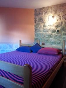 una camera da letto con un letto con cuscini viola e blu di Apartments Lanmari a Risan